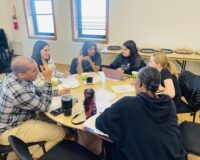 Residents discuss community decisions around a table at a meeting
