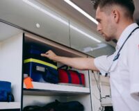 Emergency responder retrieves medical bags from an ambulance storage compartment