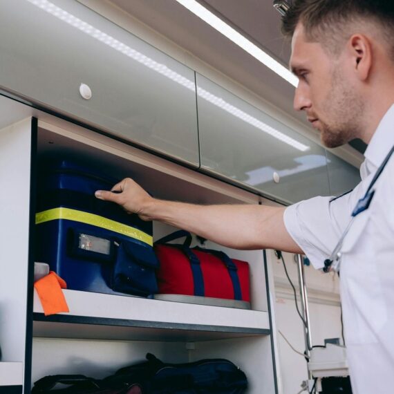 Emergency responder retrieves medical bags from an ambulance storage compartment