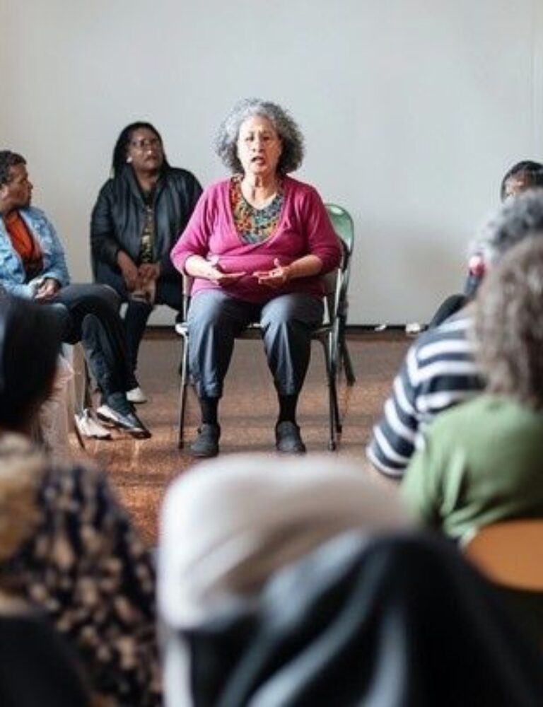 Diverse group seated in a circle during a community discussion